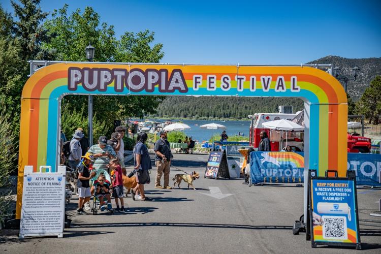 Puptopia 活动入口,背景是人们和他们的狗以及远处的湖。