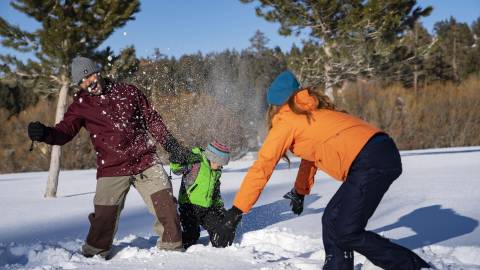 大熊湖的冬天,一家三口在雪地里玩耍。