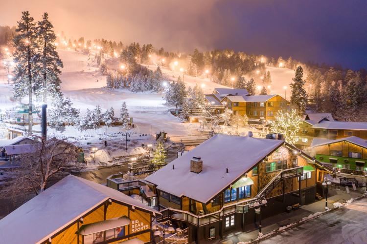 在冬季,雪峰山夜间灯火通明,适合夜间滑雪。积雪覆盖了建筑物和树木。