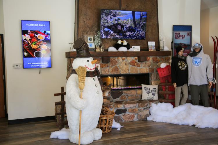 A photo of the Big Bear Visitor Center video and fireplace display, there are winter decorations from Hollywood at Santa Land