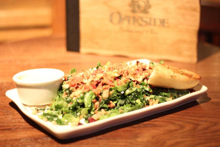 加利福尼亚州大熊湖 Oakside 餐厅的一盘沙拉、一块面包和一杯沙拉酱。